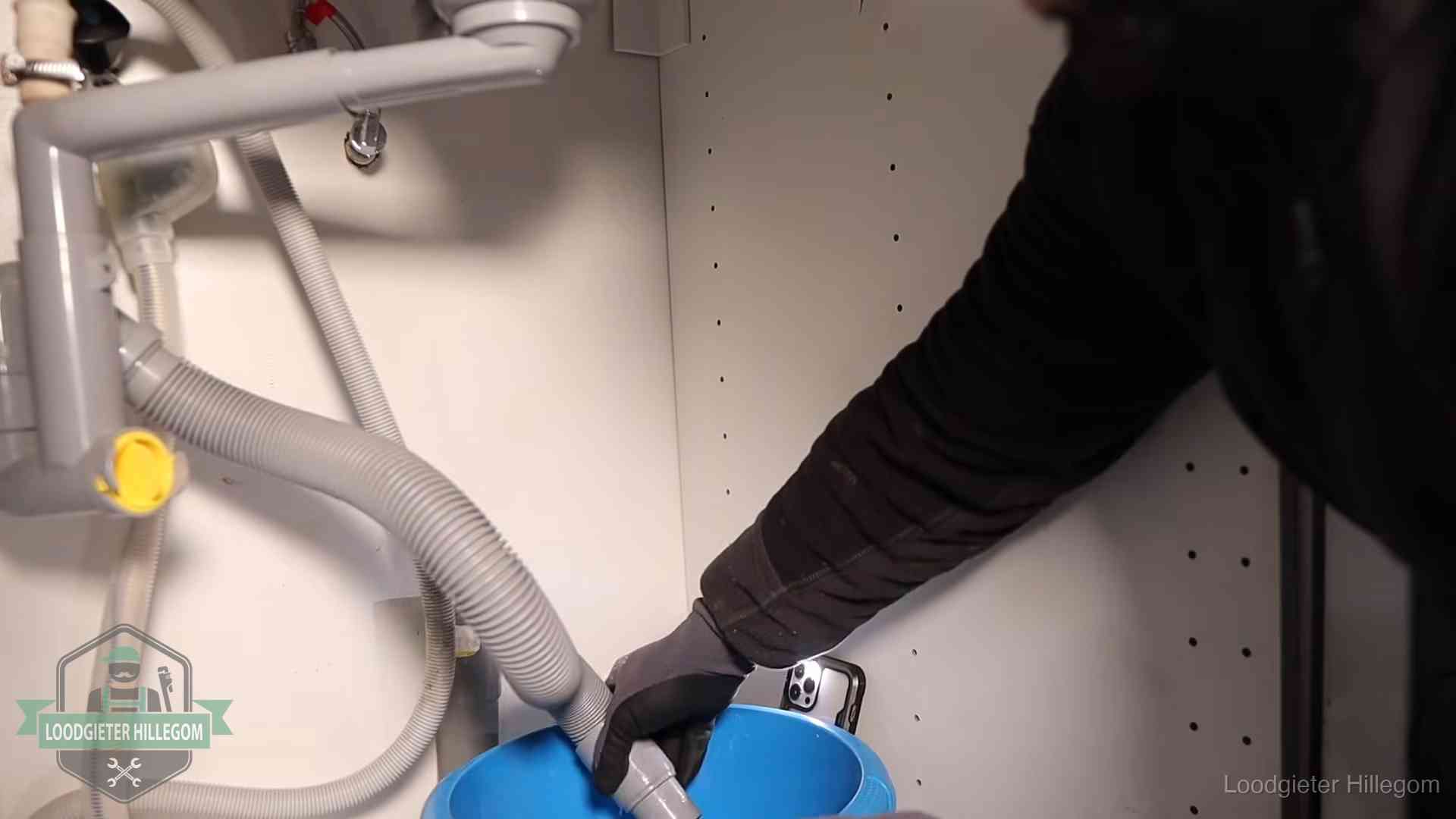 Afvoerslang loopt leeg in een emmer onder de gootsteen in Hillegom, een klus die je zelf kunt doen