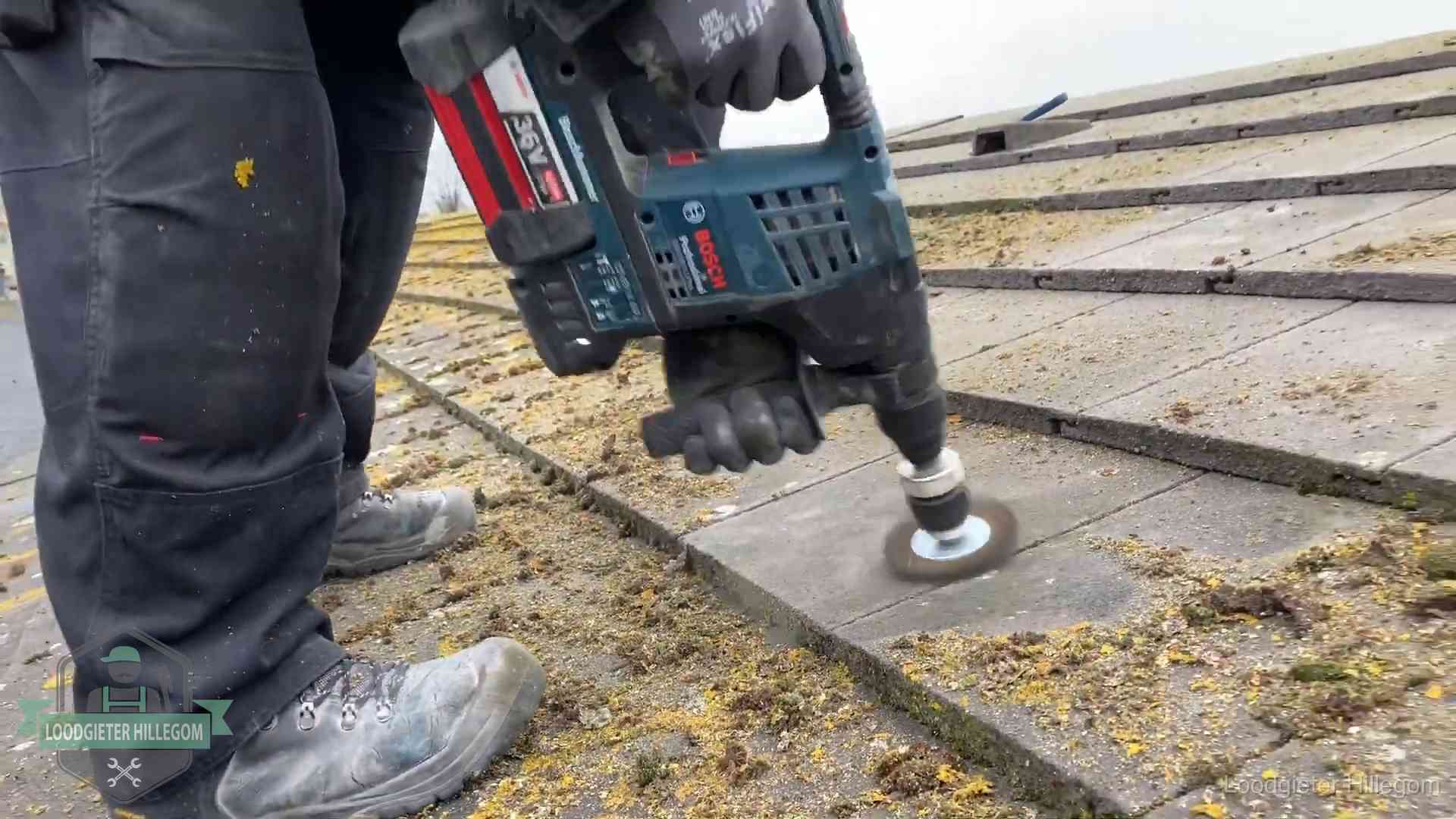 Betonnen dakpannen worden machinaal gereinigd tijdens dakonderhoud in Hillegom