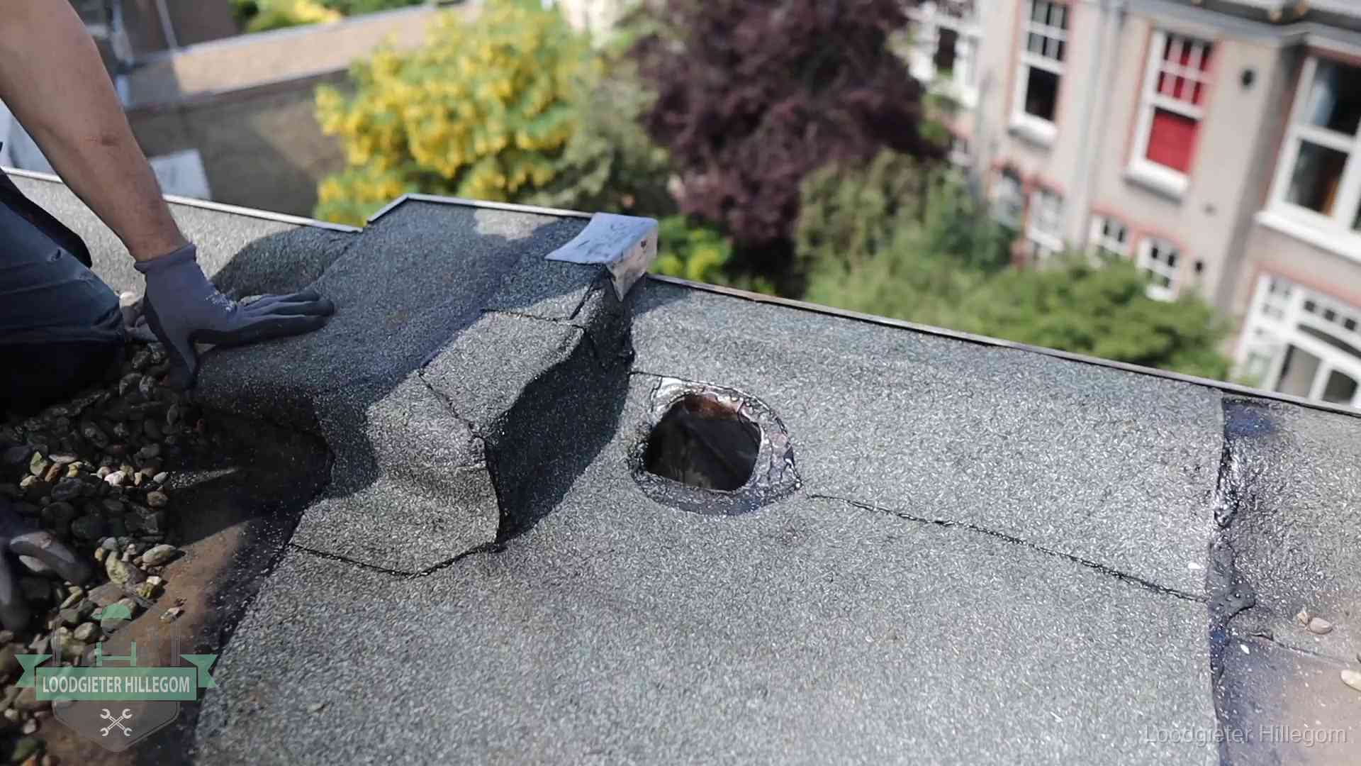 Loodgieter inspecteert een beschadigd bitumen plat dak tijdens een daklekkage-inspectie in Hillegom