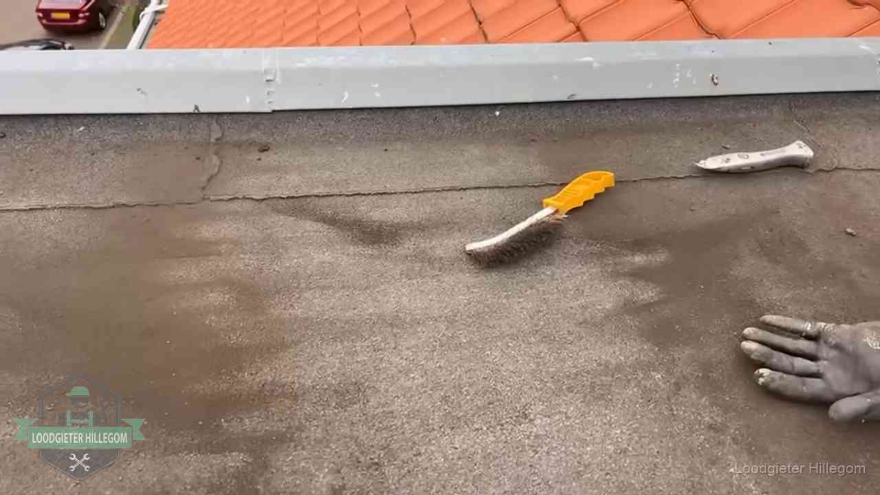 Dakdekker bereidt een bitumen plat dak voor op reparatie bij de daktrim in Hillegom