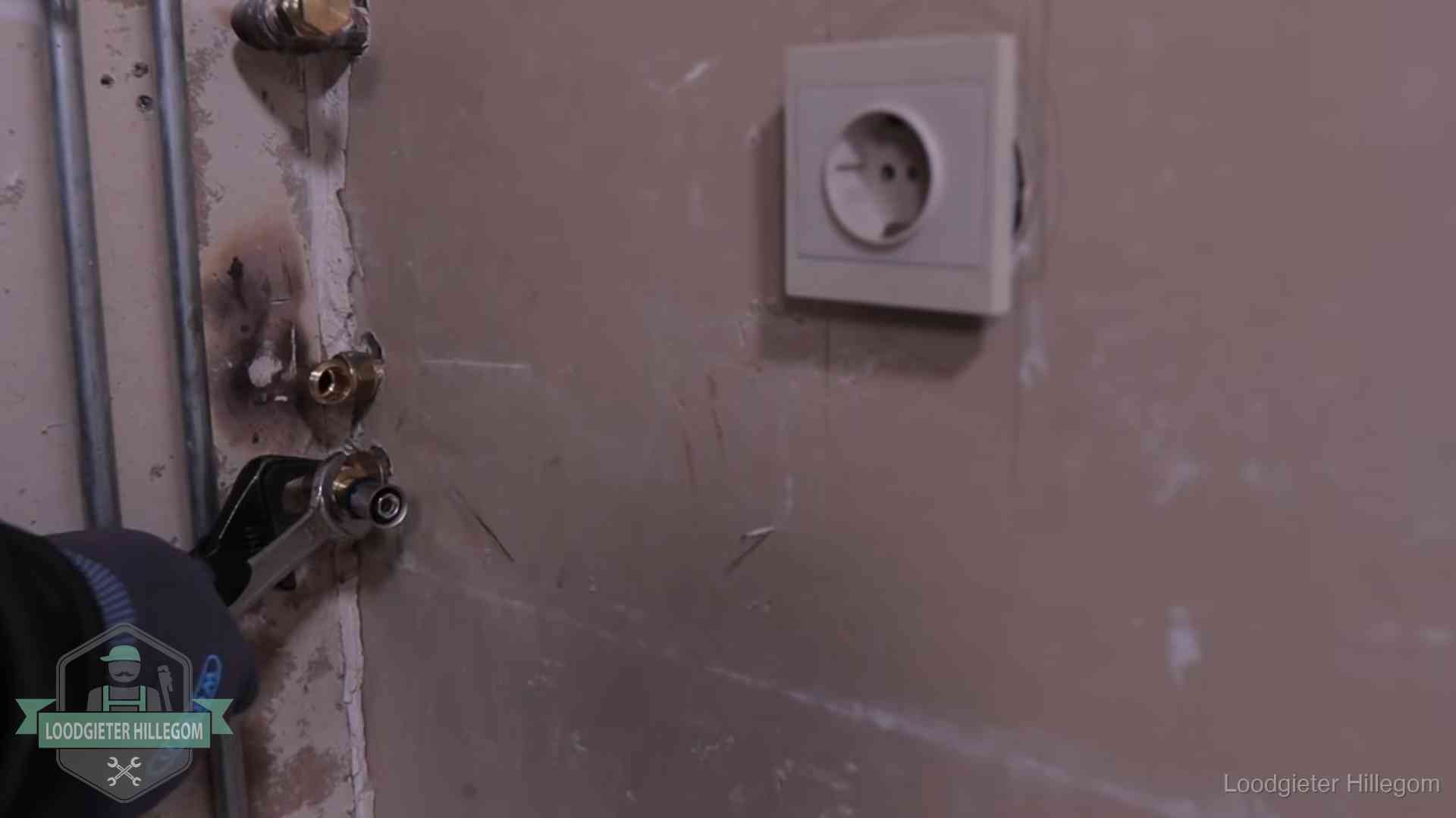 Monteur draait een perskoppeling vast op een leidingaansluiting in Hillegom