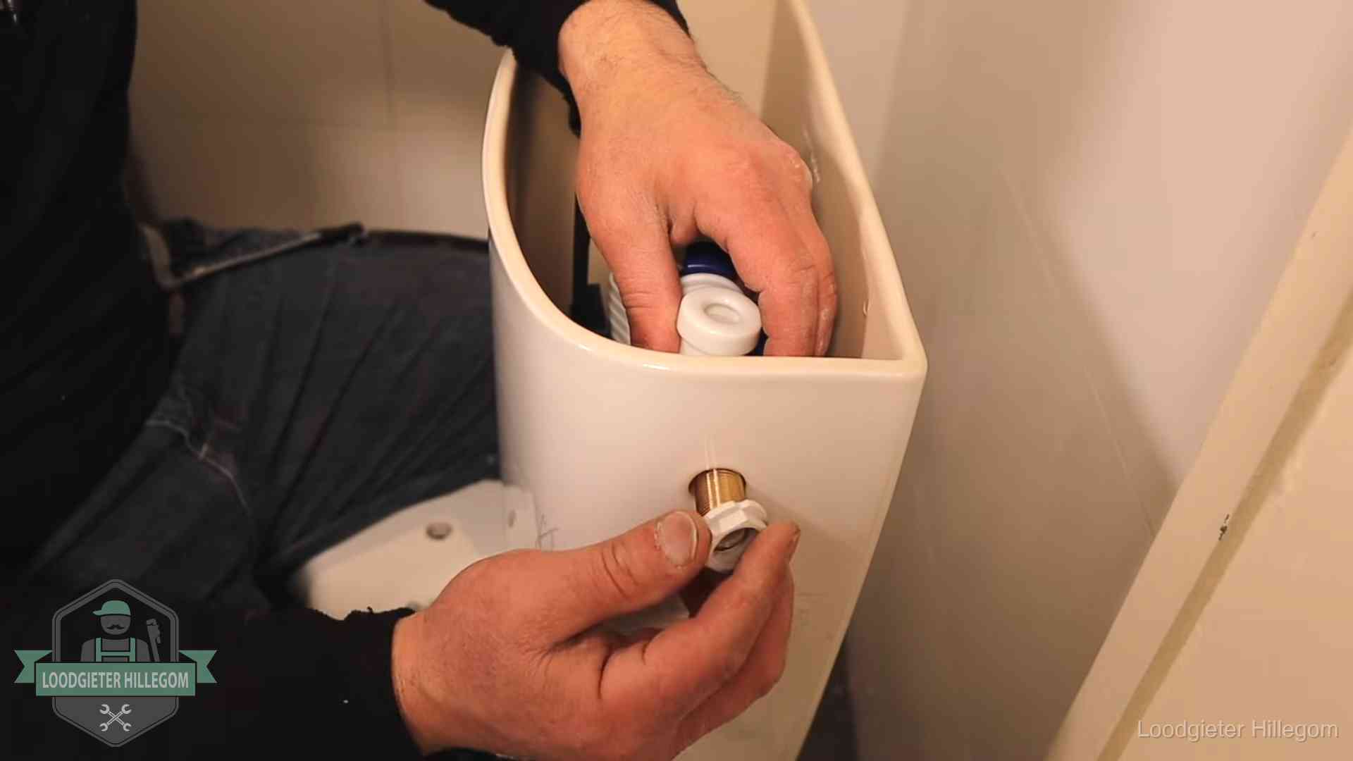 Loodgieter monteert de vlotterkraan van een stortbak bij een toilet in Hillegom