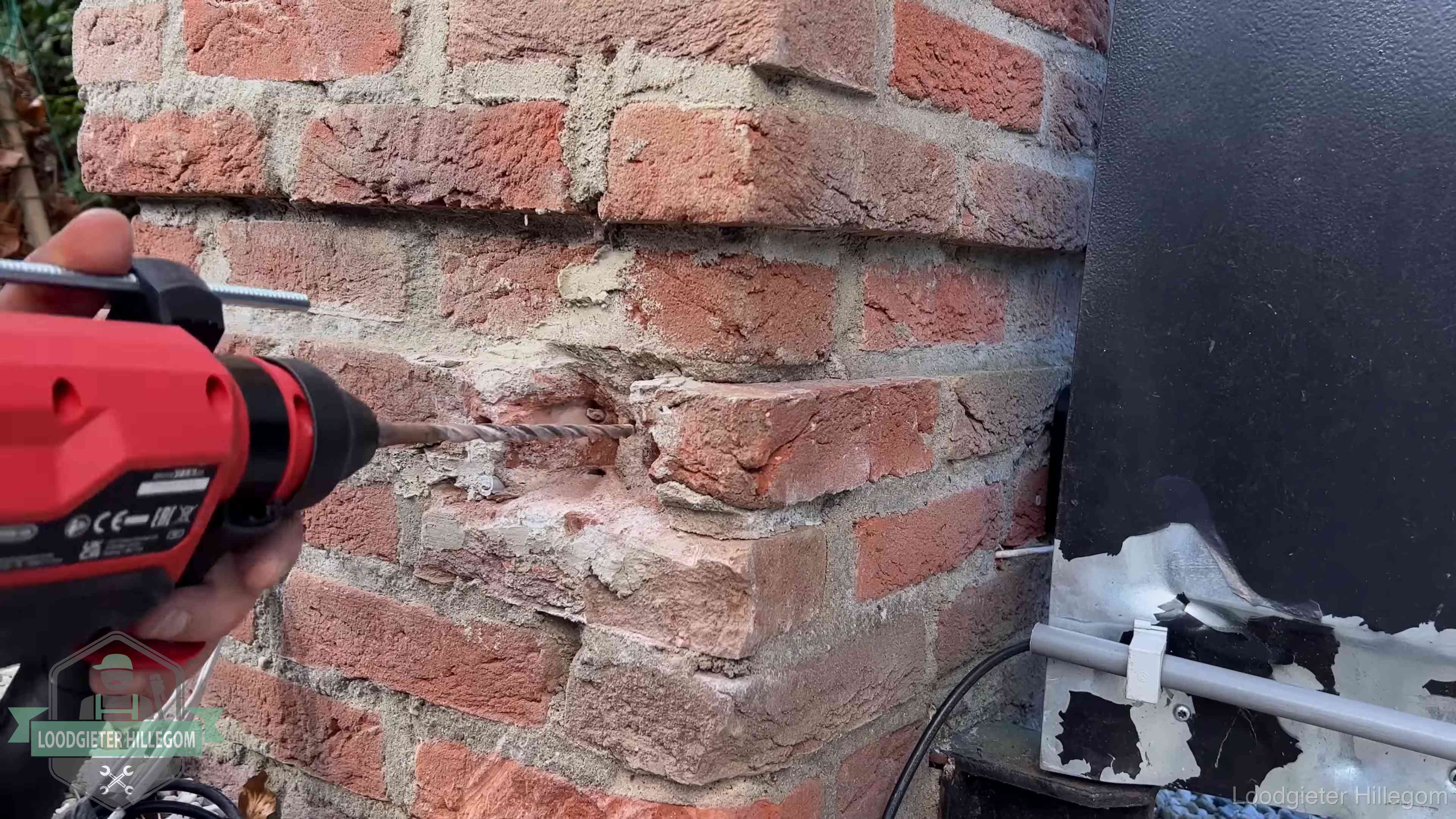 Vakman boort in de buitenmuur van een woning in de regio Hillegom
