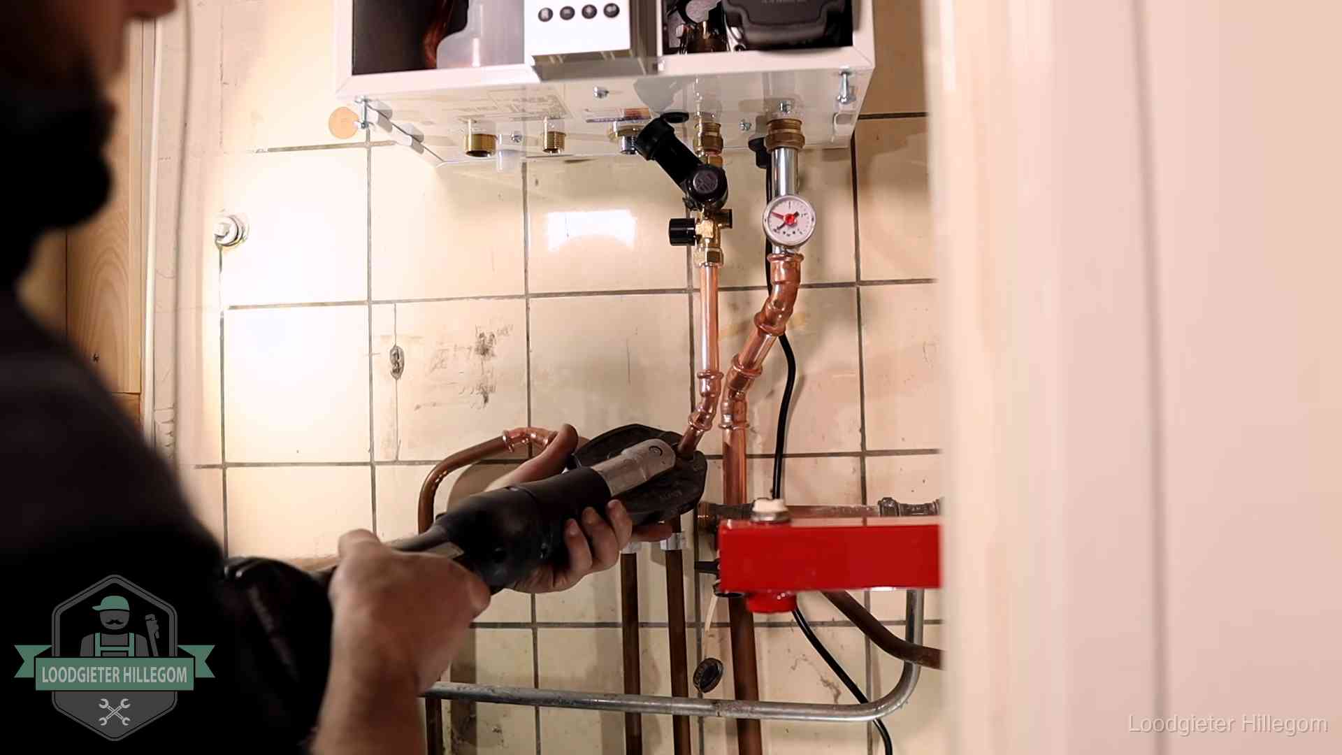 Cv-ketel onderhoud in Hillegom Monteur werkt aan de leidingen onder een cv-ketel in Hillegom