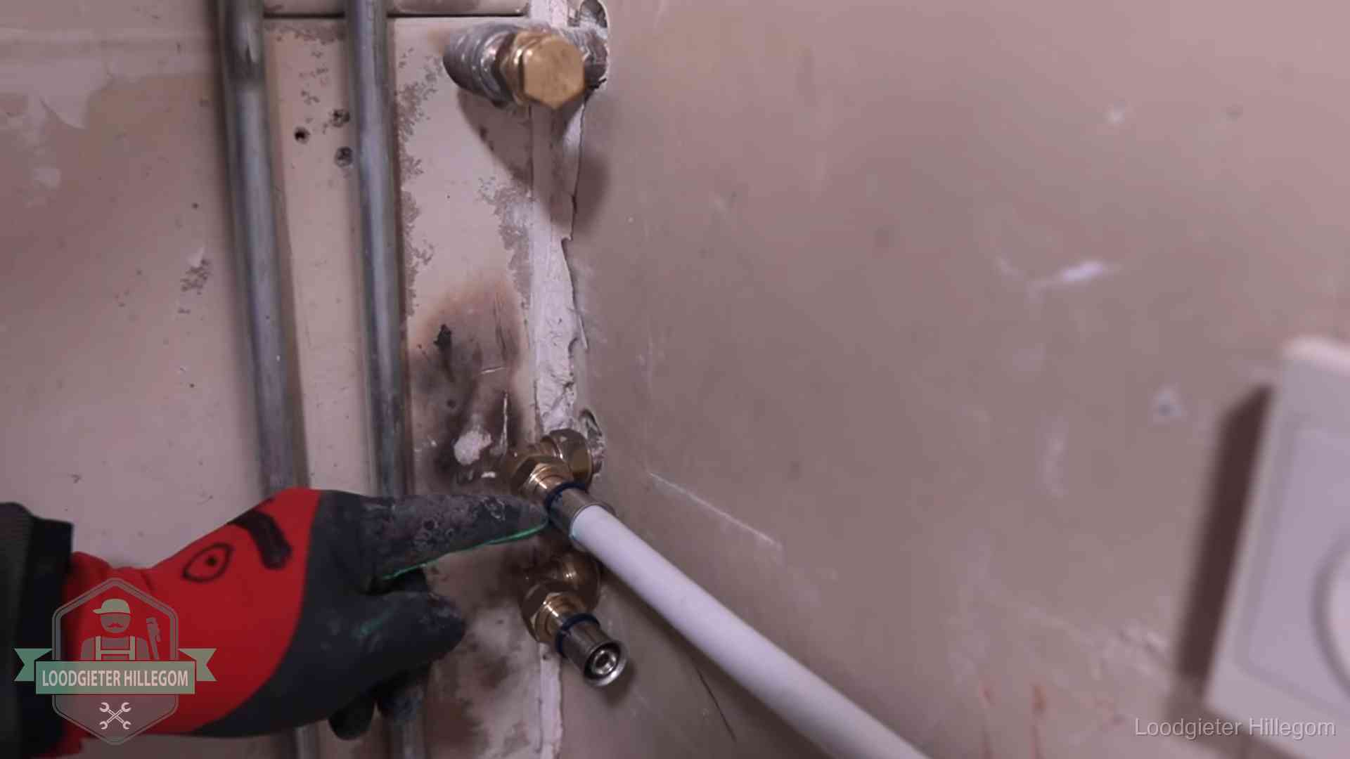 Loodgieter wijst de persfitting op nieuwe muuraansluitingen aan in een woning in Hillegom