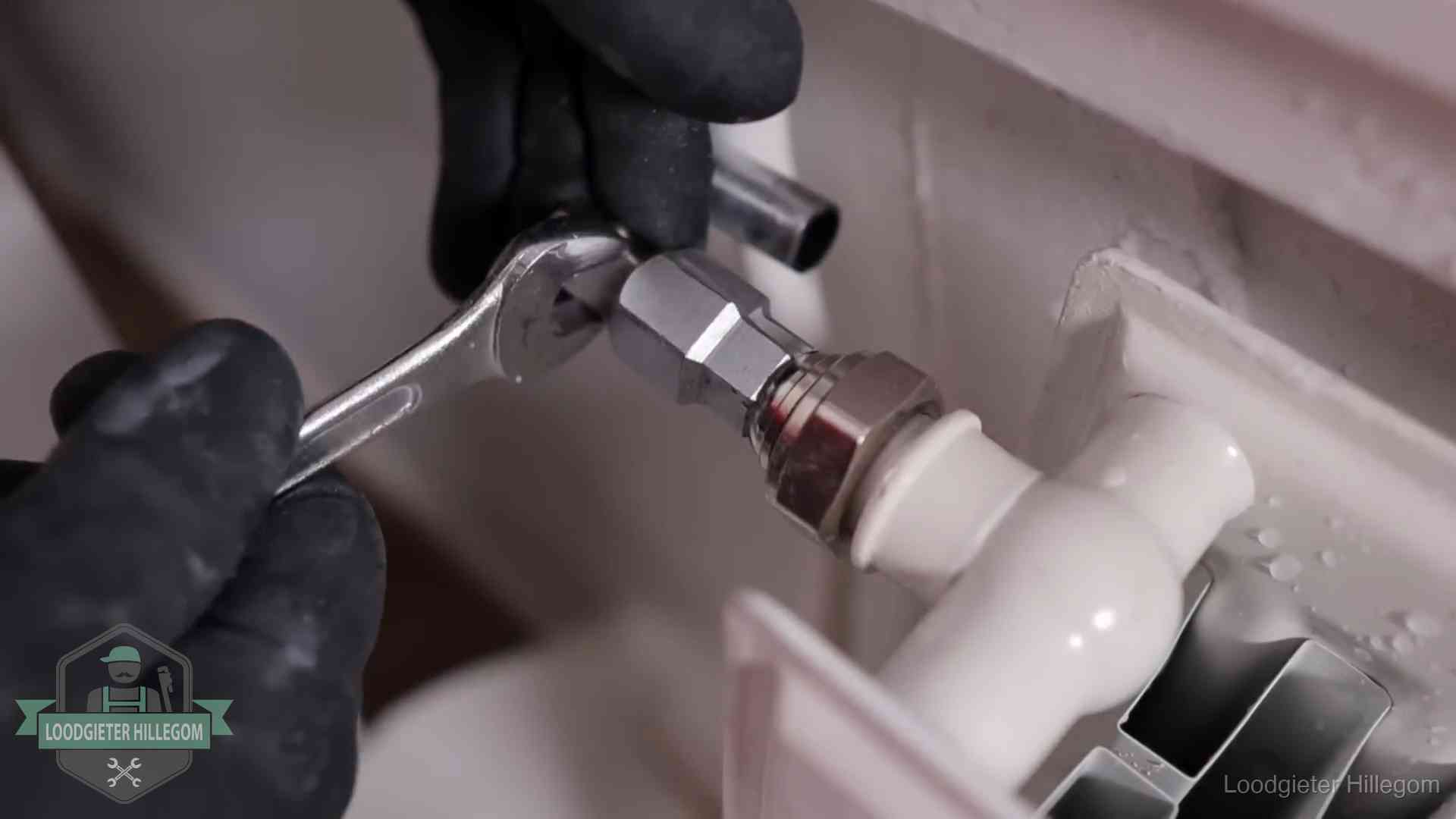 Radiatoren en waterzijdig inregelen in Hillegom Steeksleutel draait een wartelkoppeling op een radiatorkraan aan in Hillegom