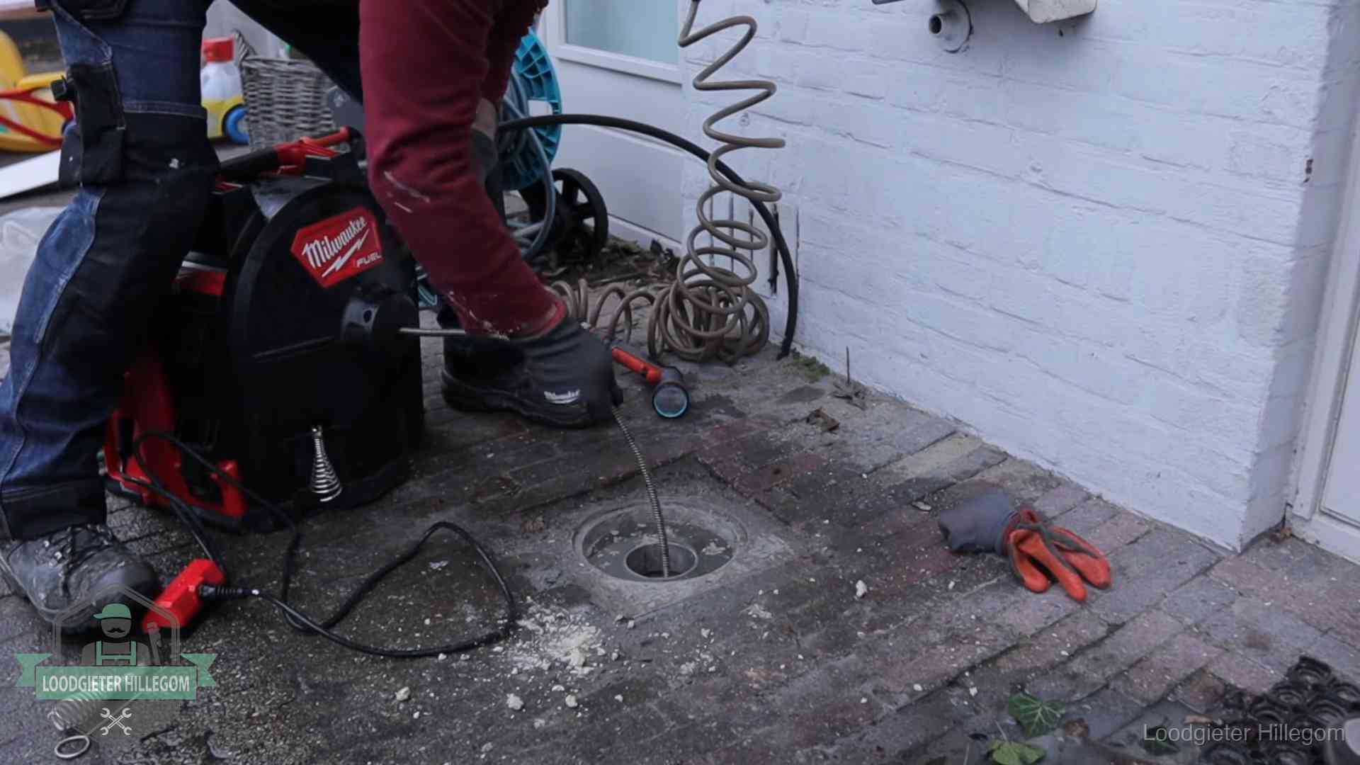Spiraalmachine bij een ontstoppingsputje in de bestrating in Hillegom