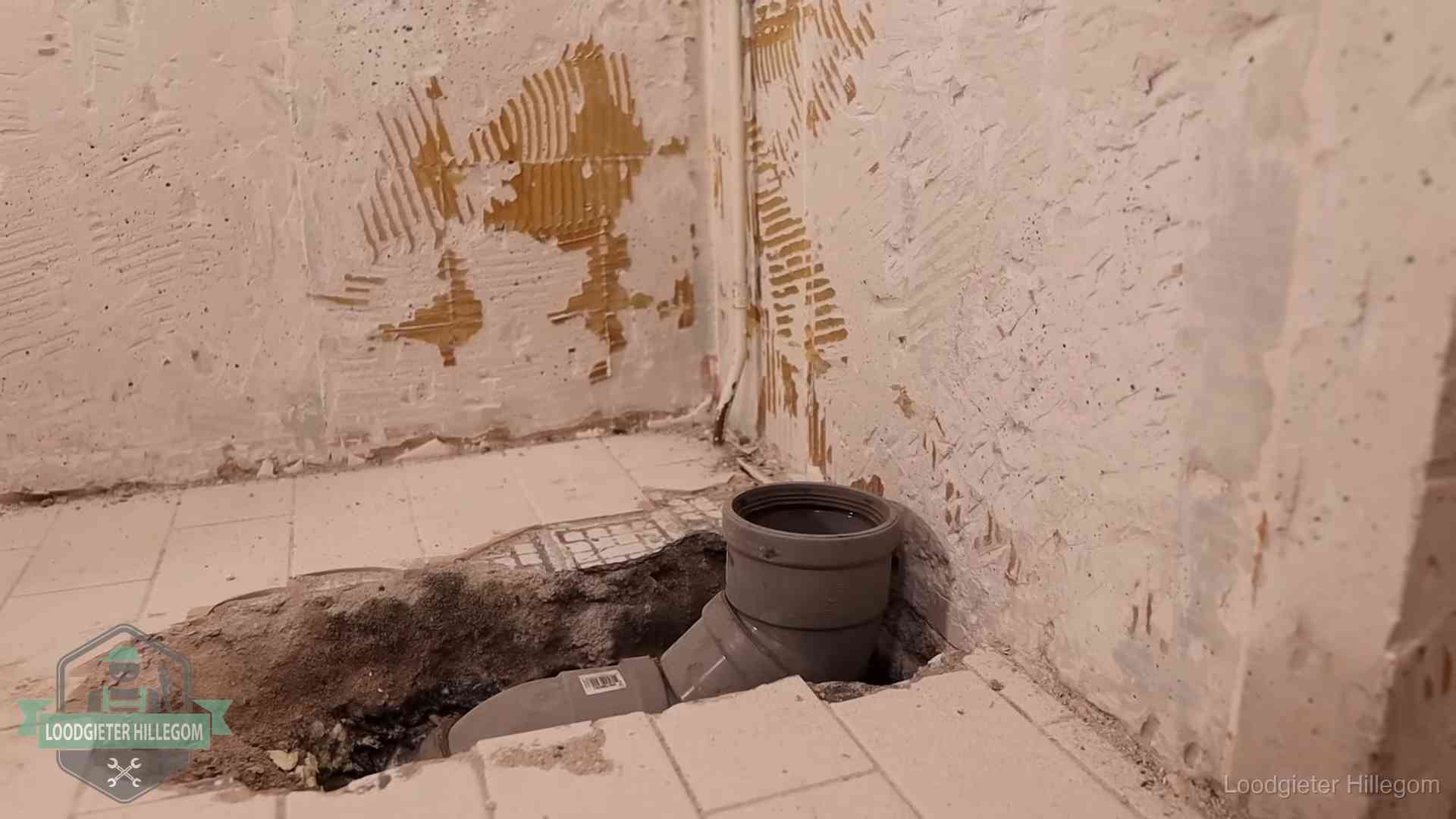 Opengebroken vloer met een nieuwe pvc-rioolbocht in een gegraven sleuf in Hillegom