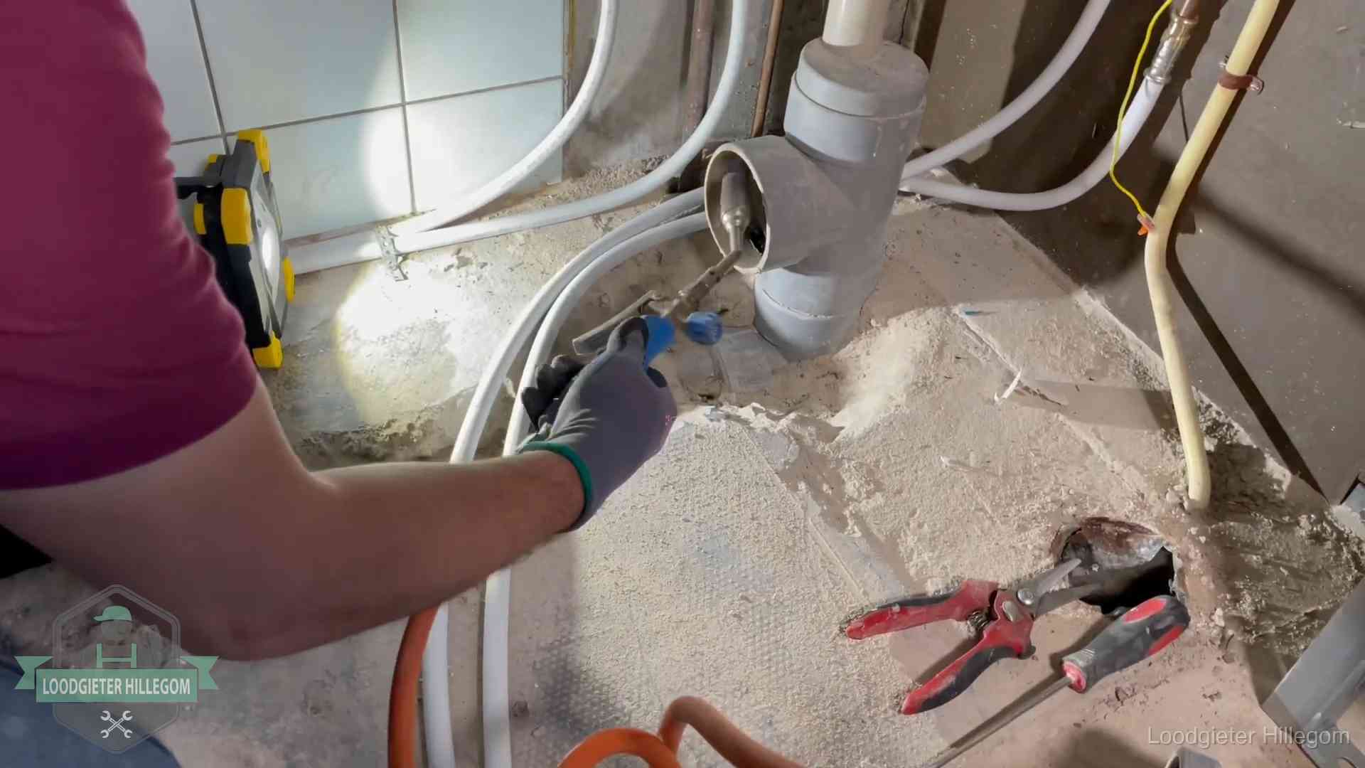 Loodgieter werkt aan leidingen bij een pvc-standleiding in een appartement in Hillegom