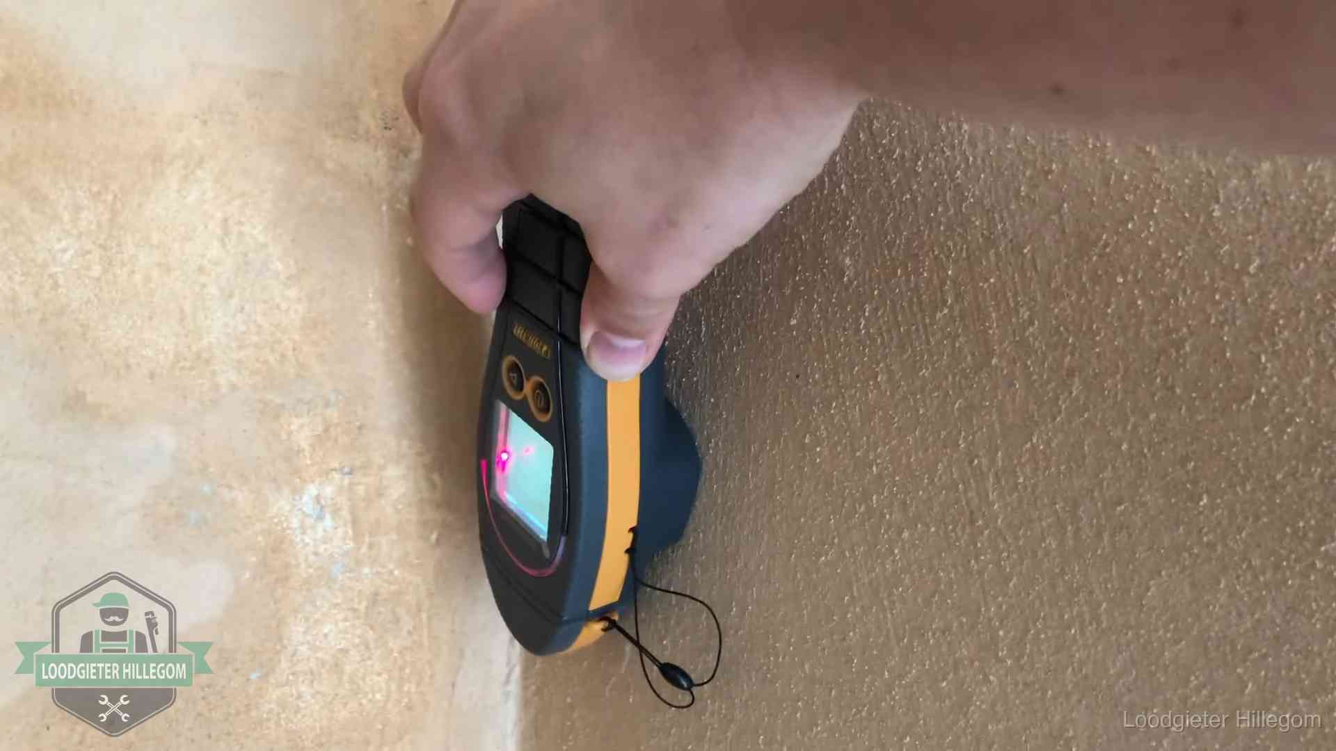 Vochtmeter tegen een muur met vochtplekken tijdens het opsporen van een daklekkage in Hillegom