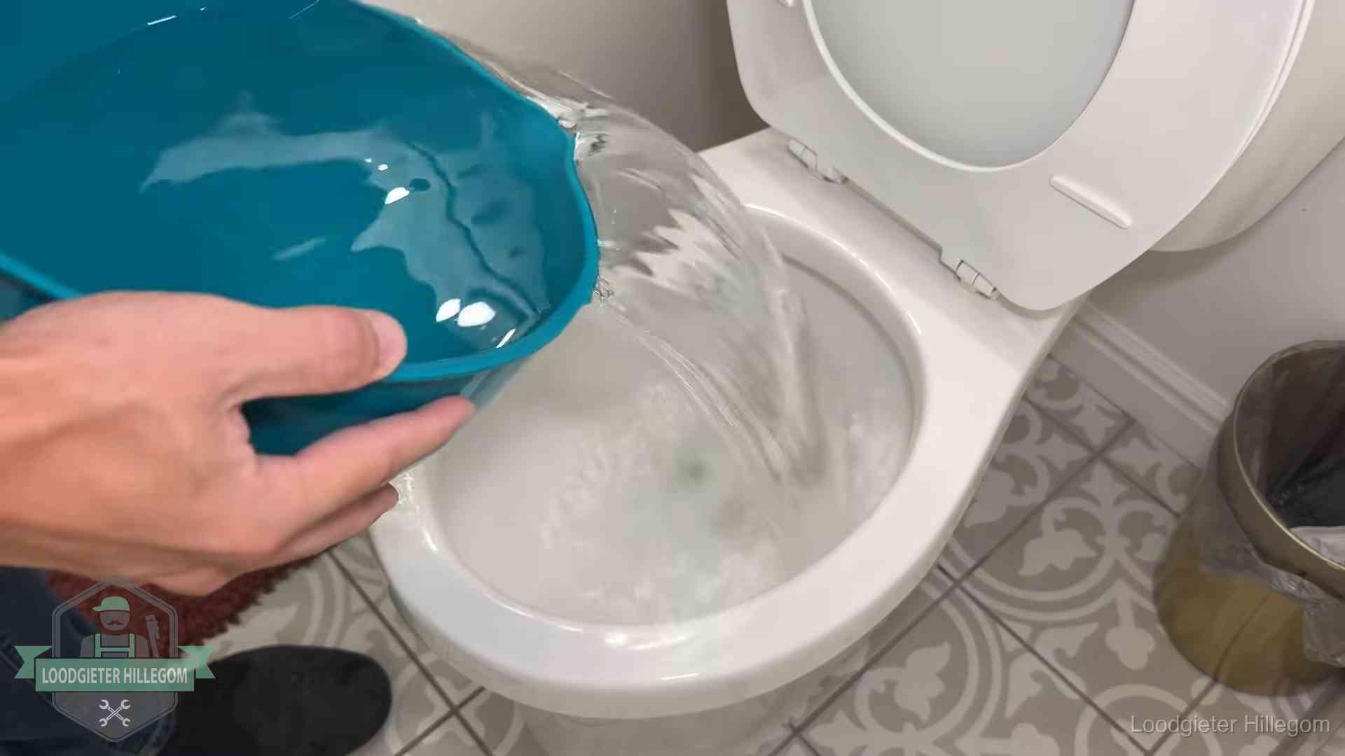 Warm water wordt voorzichtig in de wc-pot gegoten in Hillegom