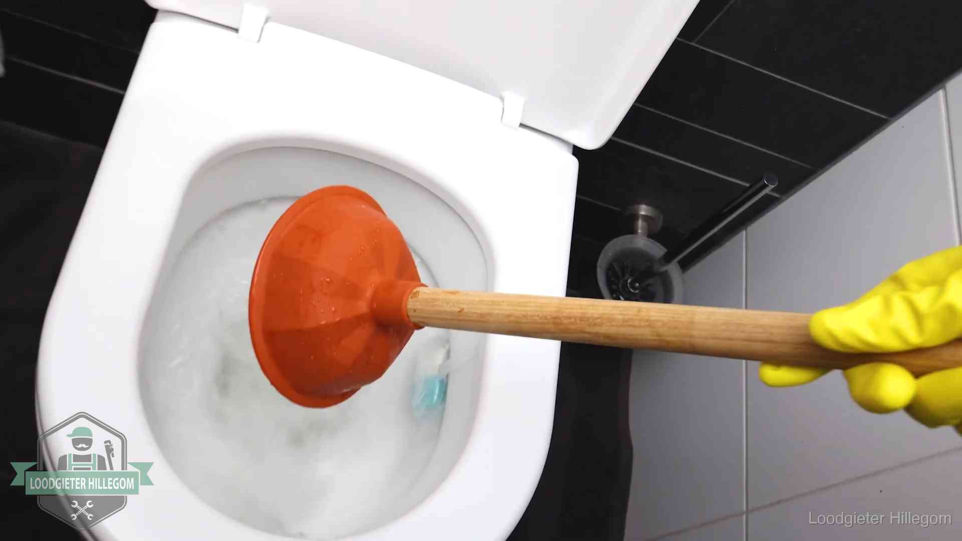 Plopper wordt in de wc-pot gedrukt bij het ontstoppen van een toilet in Hillegom