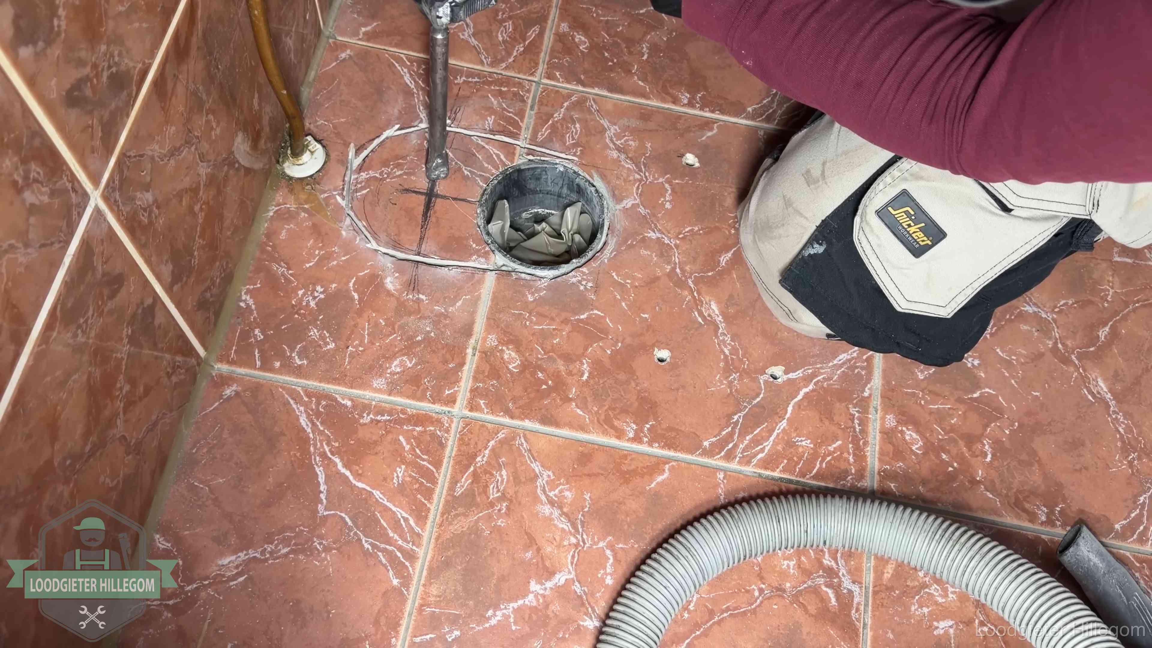 Open rioolaansluiting in de vloer waar de wc-pot is gedemonteerd in Hillegom