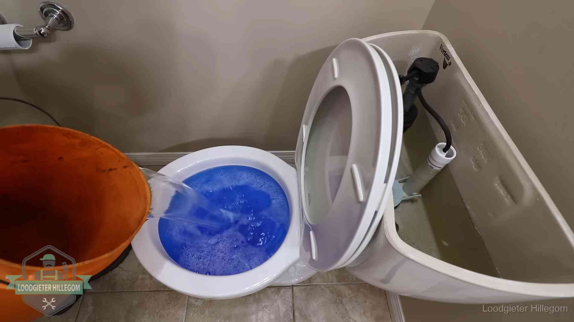 Water bij de wc-pot wordt met een emmer weggewerkt om schade te beperken in Hillegom